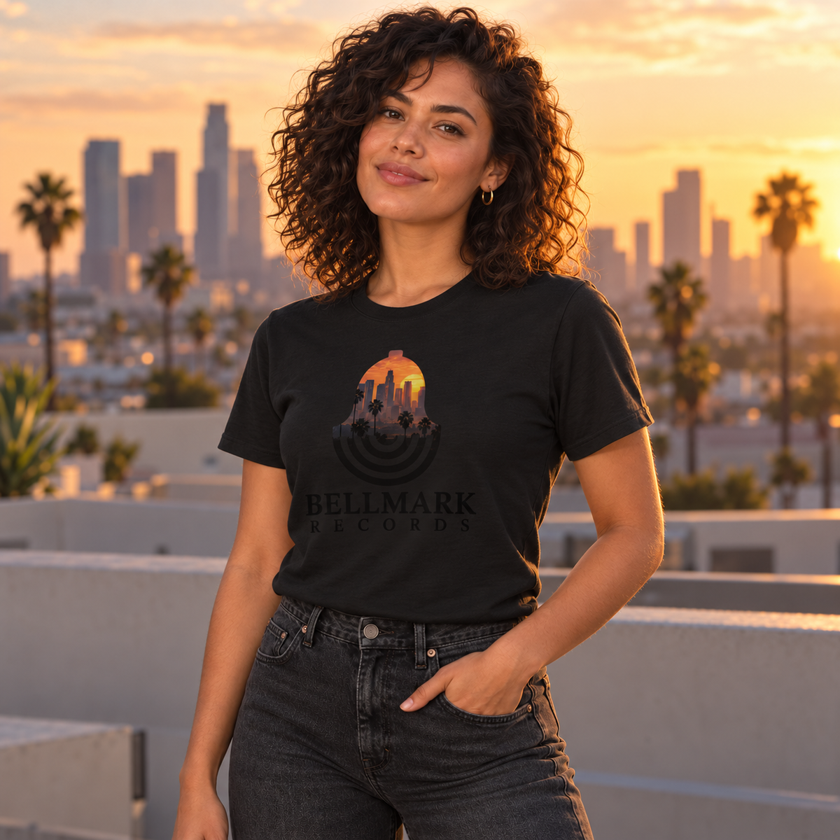 Woman wearing the black Bellmark Records Los Angeles t-shirt with a city skyline at sunset